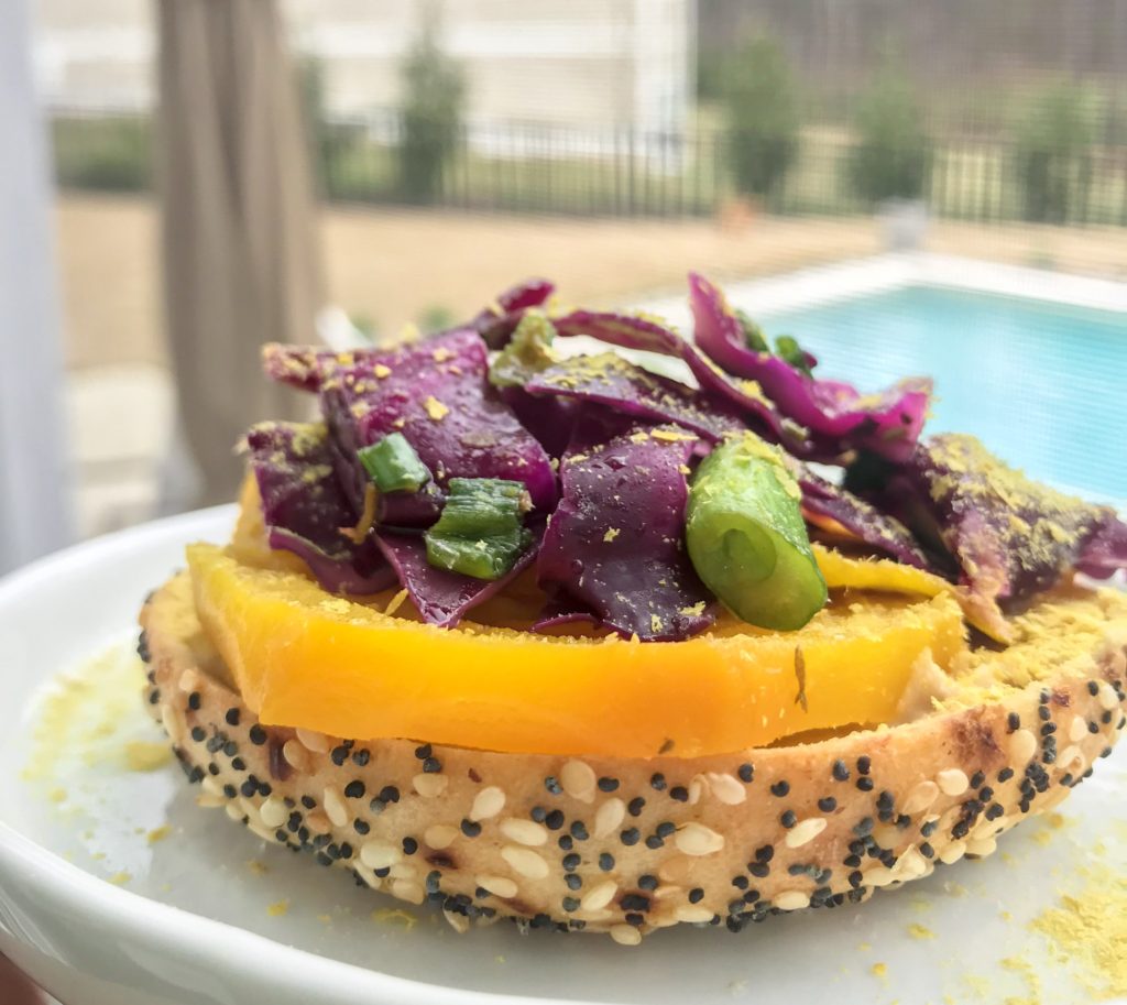 side view bagel with yellow pepper and red cabbage