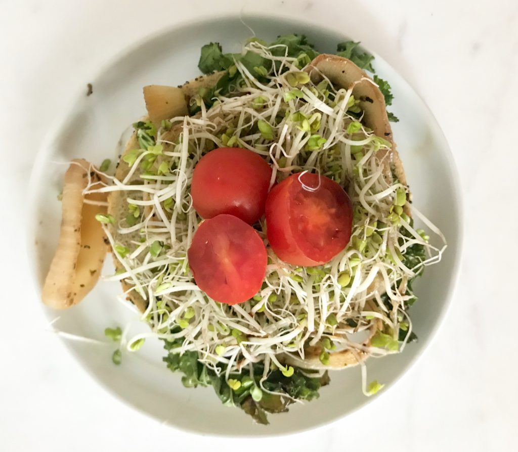 top view bagel with kale, grilled onions, broccoli sprouts, tomatoes, balsamic vinegar